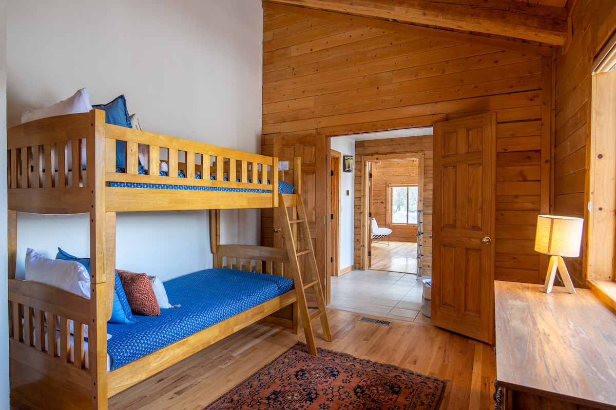 Twin-over-twin bunk room with wooden frames and blue bedding at Wildcat Cabin